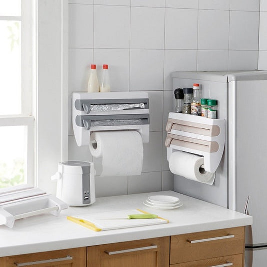 Wall-mounted white 4-in-1 kitchen roll holder dispensing paper towel, foil, and plastic wrap.